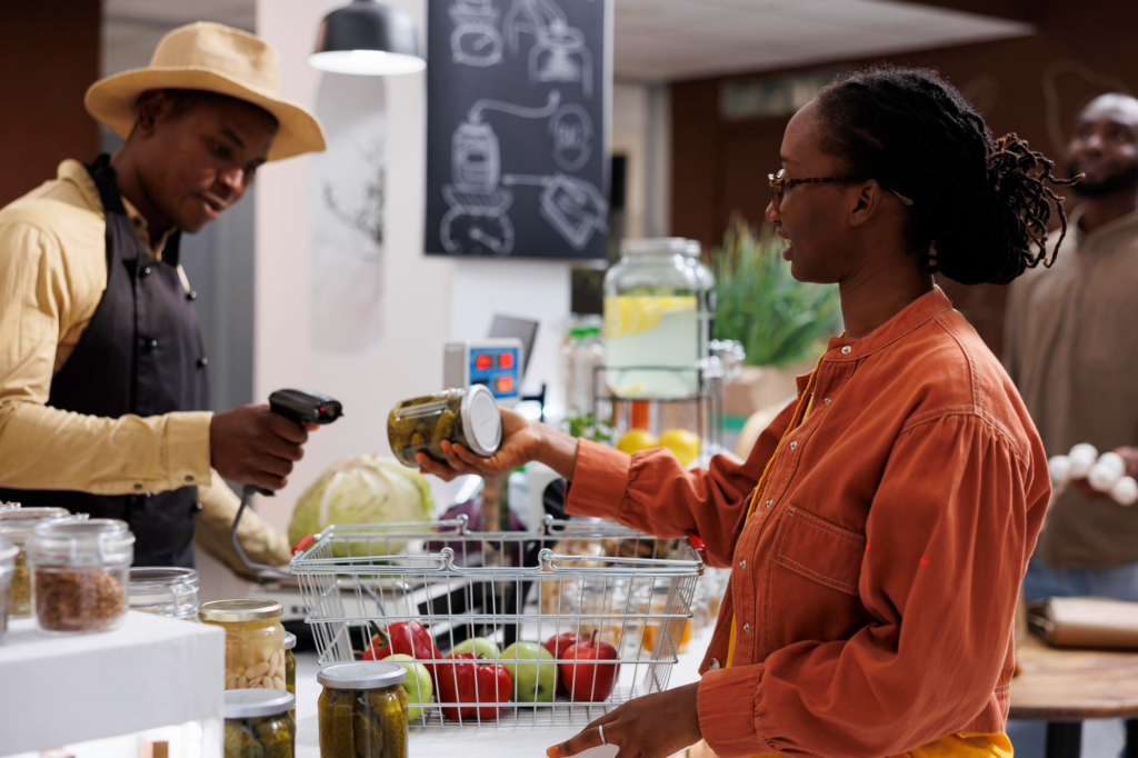 Retail Workforce Management in South Africa: Typical Challenges 1 A South African woman buying groceries, with the cashier scanning them.